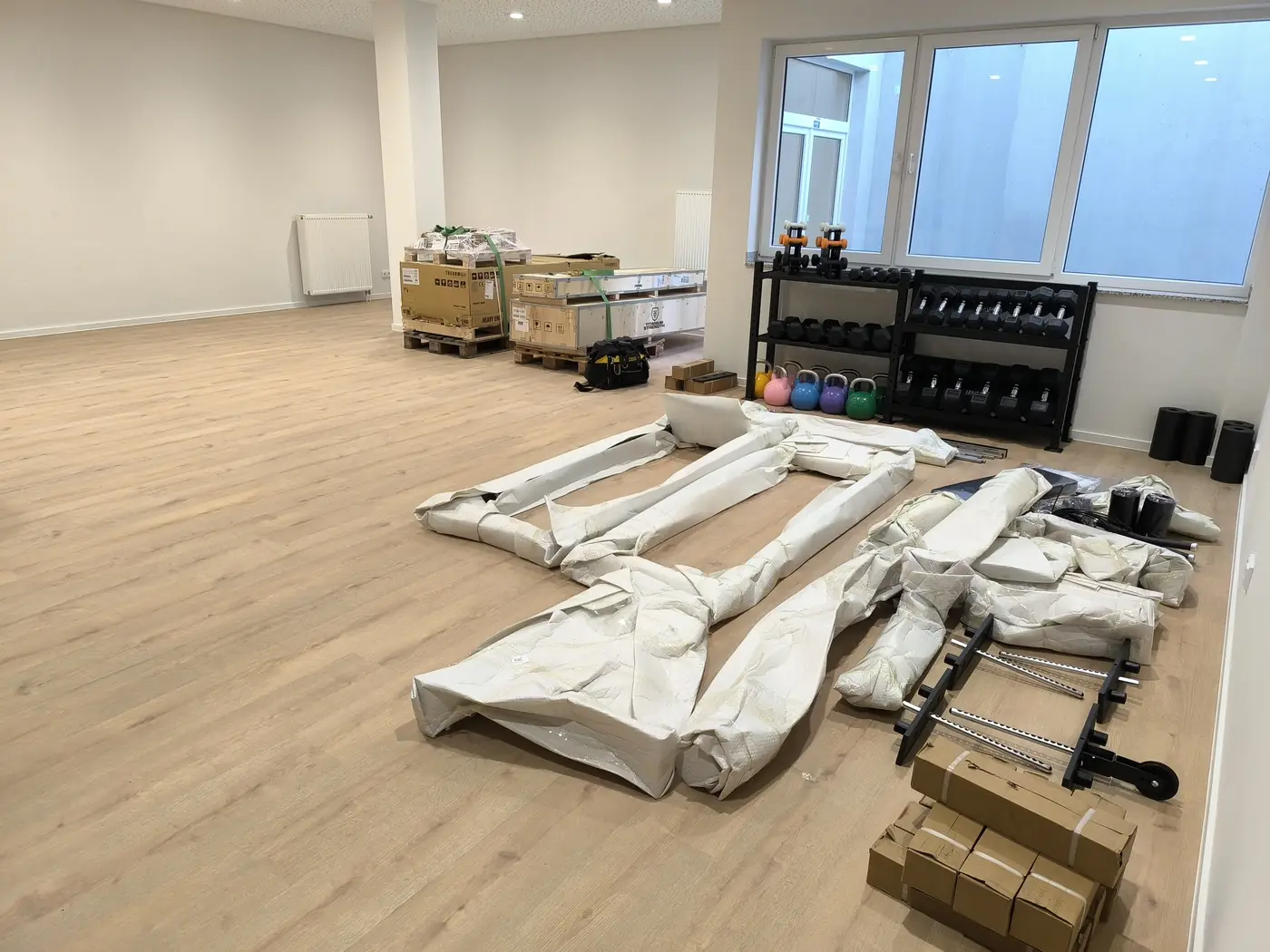 Vorher: Paletten und verpackte Rahmenteile im Trainingsraum